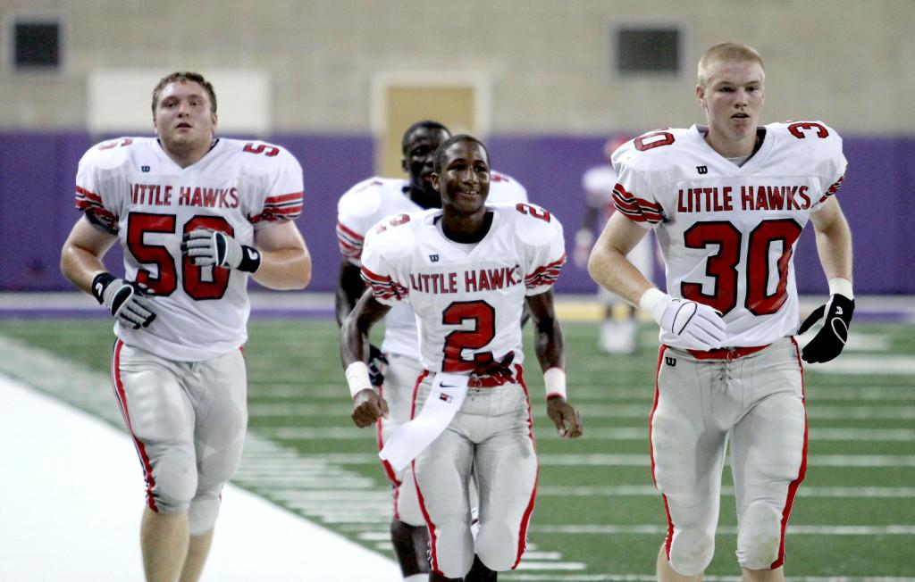 Captains Matt Lee, Amos Lavela, DeAirius Salibi, and Tyler Hill jog to the coin toss in the UNI Dome. Photo by Ryan Young.