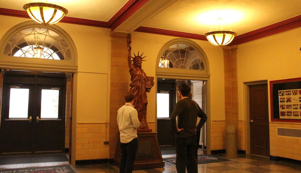 Pete Martin, Jonathan Rogers, and Doug Lestina stand in front of the original Lady Liberty in the Main Foyer of City High School.  Photo by Rachel Gralnek