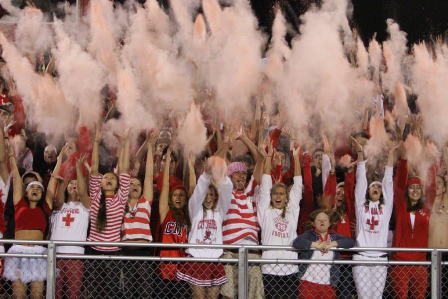 Students tossing red baby powder in the air during kick off. 