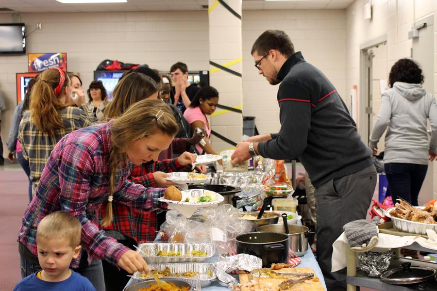 Attendees are served food; Best Buddies contributed two 30 pound turkeys, gravy, and mashed potatoes, while the rest was a potluck among the classes.