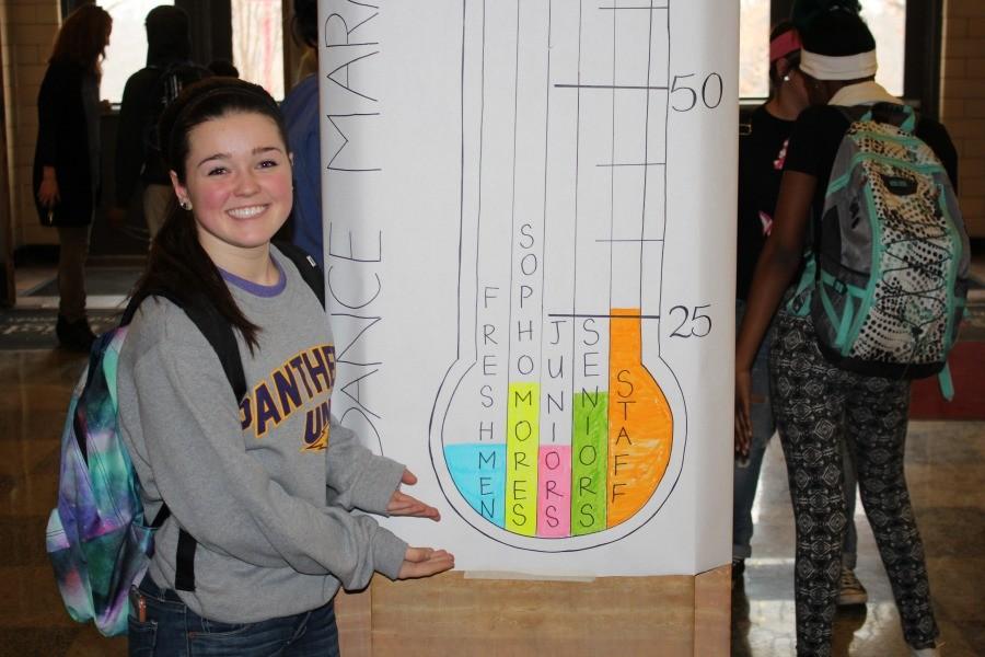 Katrina Scandrett an organizer of Dance Marathon stands in front of their fundraising chart.  She is hoping to raise thousands of dollars by February 5th.