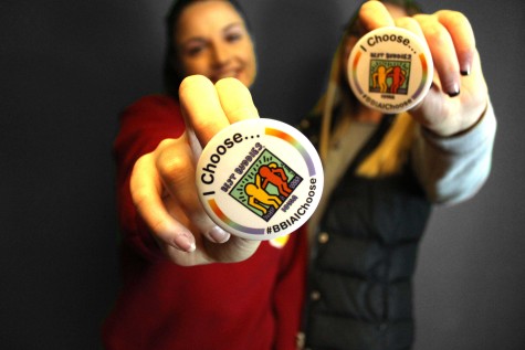 Seniors Payton Evans and Lillie Christopherson show their support buttons for the Spread the Word to End the Word Campaign.