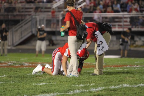 Nate Wieland '17 struggling to hold himself up while being checked on by training staff.
