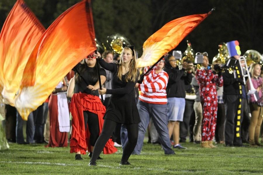 Color Guard performs with the band at the Halloween football game half time show