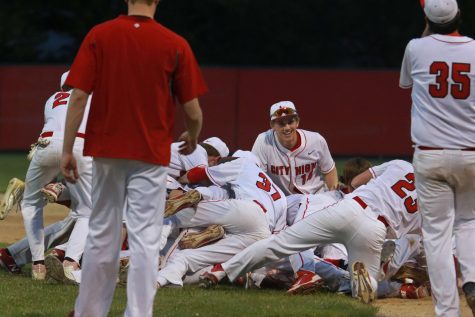 Dylan Deshler 17 (14) smiles while teammates pile on top of Caleb Sass 17 after their victory over Clinton at Mercer Park on May 26th, 2016.