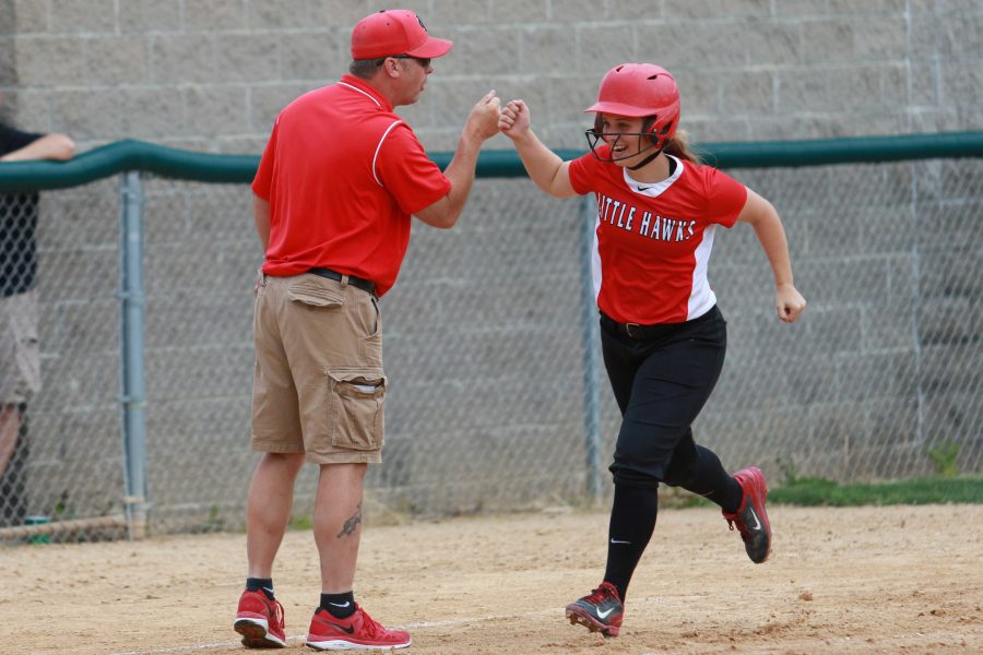 Maggie Cremers '19 bumps fists with the Little Hawks' head coach Jeff Koenig as she rounds third base after hitting a homerun during City High's crosstown rivalry doubleheader at West High on Tuesday, May 31st, 2016.