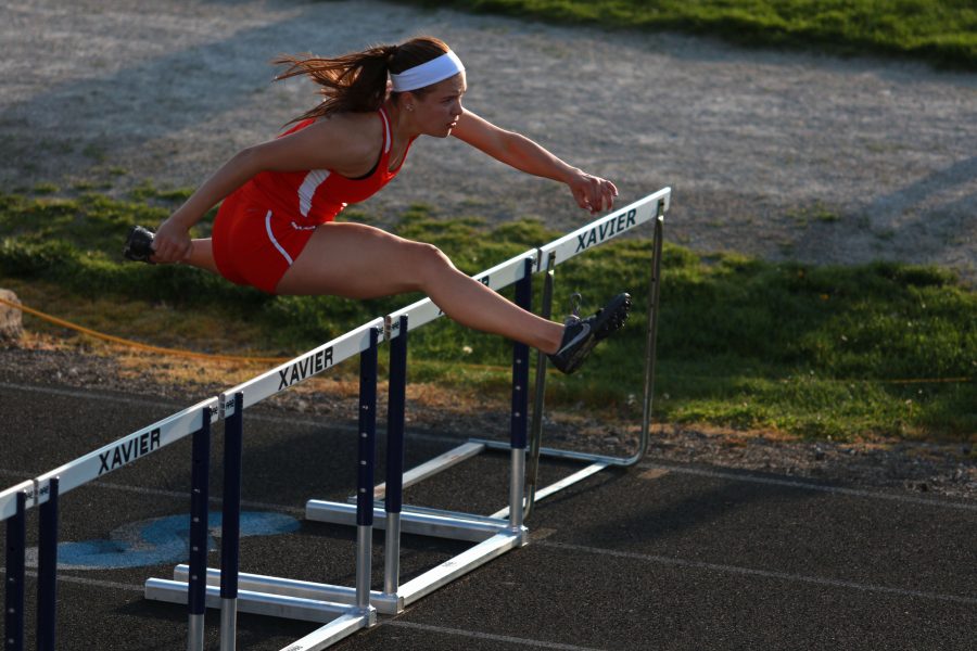 Elke Windschitl 16 clears an obstacle in the 110 meter hurdles at the Mississippi Valley Conference divisional meet.