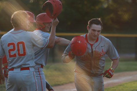 Teammates celebrate with Brett McCleary 17 after his homerun during the Little Hawks first game against Pleasant Valley.  City High defeated the Spartans after 12 innings topping them (10-9) on Wednesday, June 29, 2016.