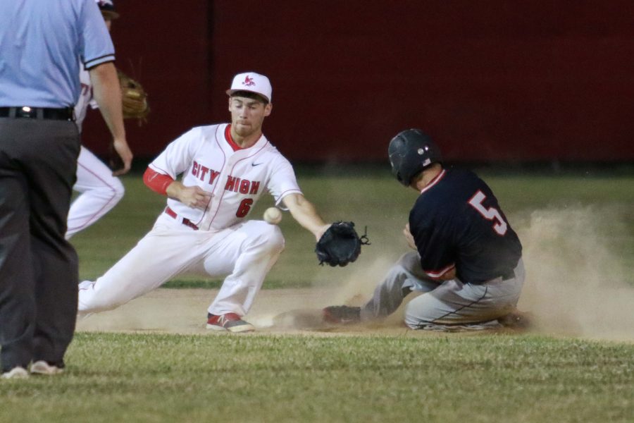 Dylan Leigh 16 takes a ball to the knee while a Linn-Mar, Marion player slides safe into second at Mercer Park in Iowa City on Monday, June 20, 2016.