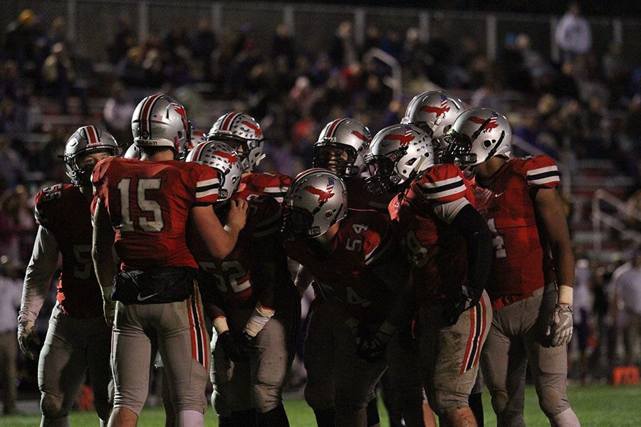 QB Nate Wieland 17 and the offense stand in the huddle.