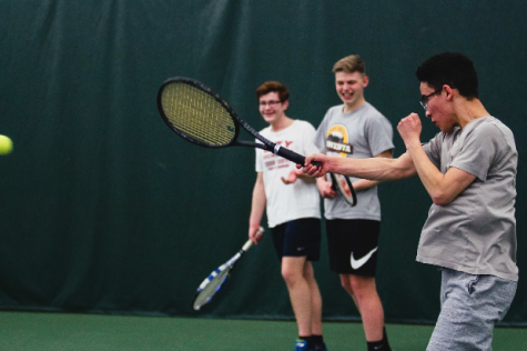 Miles Pei ‘18 strikes the ball in practice as Kahleb Fallon ‘19 and Jack Motto ‘19 look on. 

