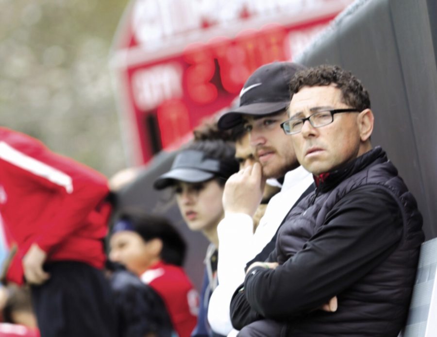 Boys soccer coach Jose Fajardo watches the boys team on the turf field at City High. 