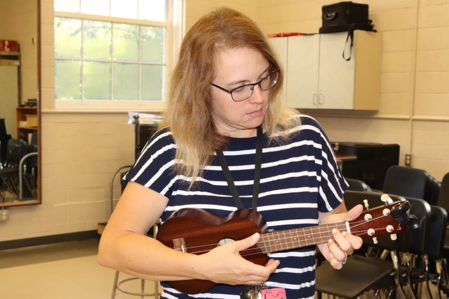Mrs. Fields-Moffit strums her ukulele in her classroom. 