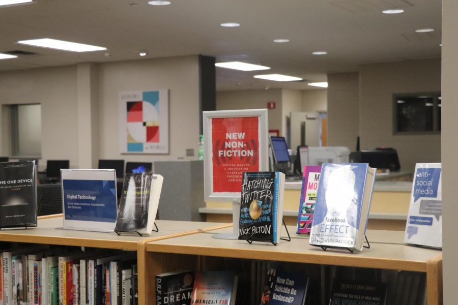In front of the checkout desk, a bookshelf displays new books for students and staff to see.