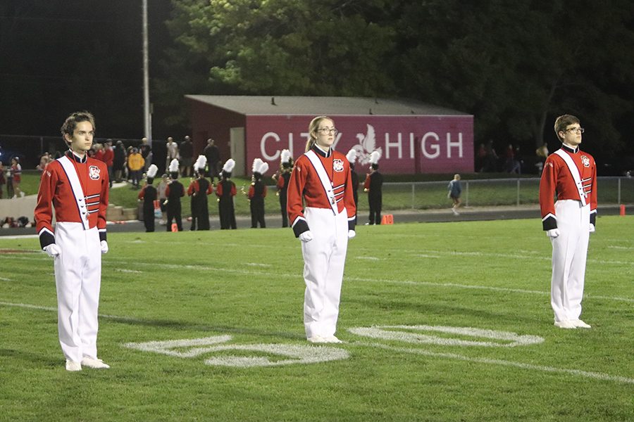 Drum Majors Joseph Bennett 20, Katherine Itrona 20, and Toby Epstein 21 Saluting the audience for the marching pre-game to start.