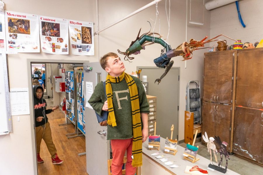 Finnegan Shelton ‘20 stands next to his dragon sculpture.