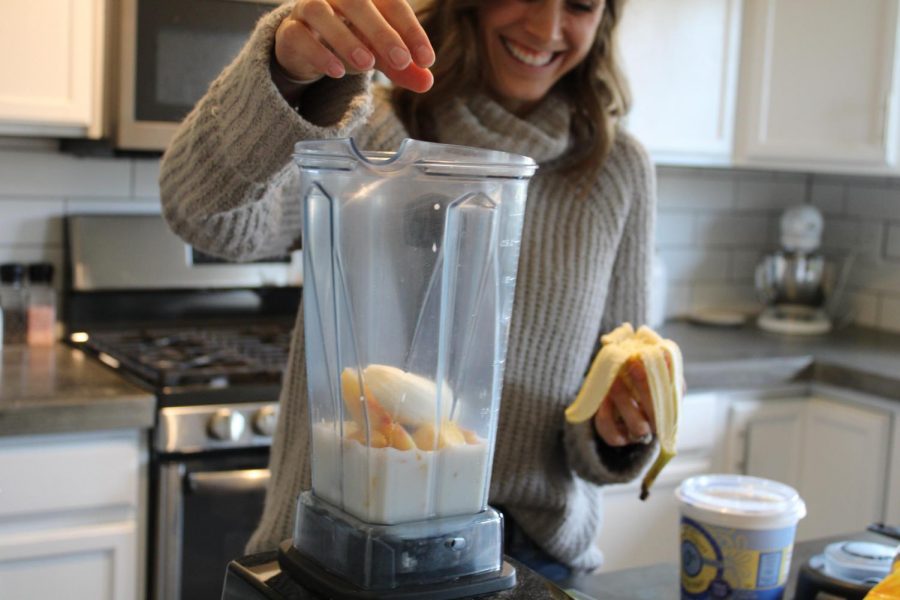 Coach Hodge adding bananas to her smoothie. 