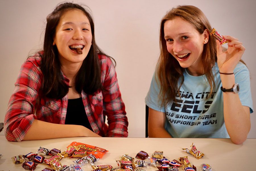 Julianne Berry-Stoelzle 21 and Rika Yahashiri 21 sit in fount of a mound of Halloween candy.