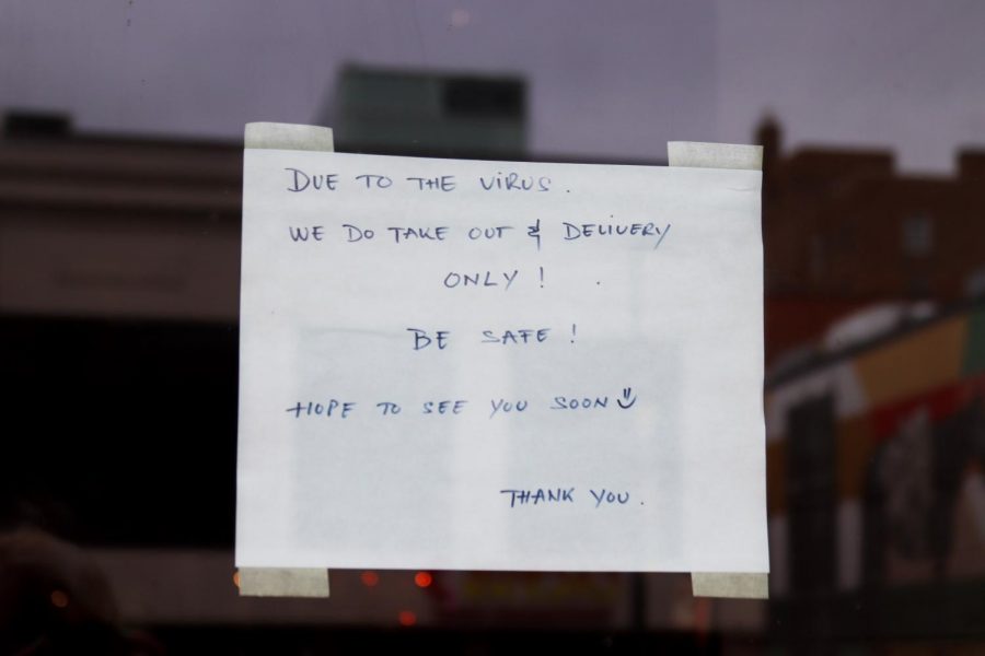 A downtown store front posts a sign of closure because of COVID-19.
