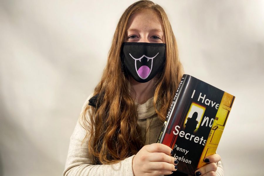 Kate Kueter 21 poses with the book I Have No Secrets by Penny Joelson.