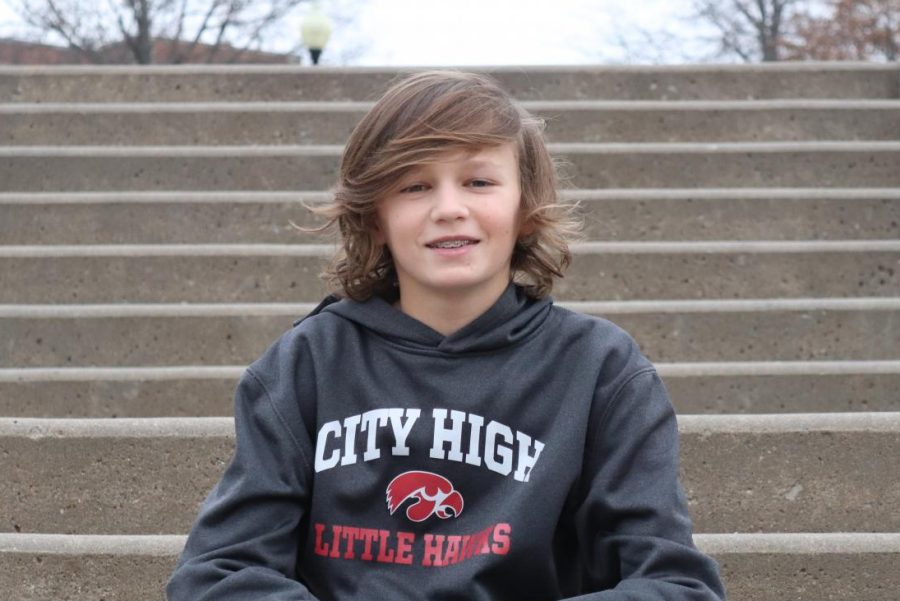 Arthur Hall 24 poses for a picture on the front steps of City High. As a freshman, he is already one of the best players on the City High boys golf team.