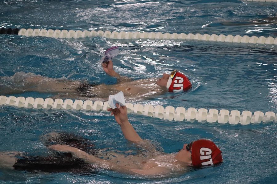 Jared Coiner 23 and Chase Loftus 22 swim to the other end of the pool holding their masks above the water