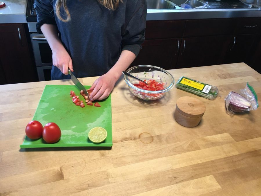 Lily Vanderlinden 21 chops up tomatoes for a salsa recipe. 