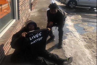 Soumaila Sanogo ‘23 and Shamar Benton ‘23 give free Two Kids Apparel shirts to the homeless. 