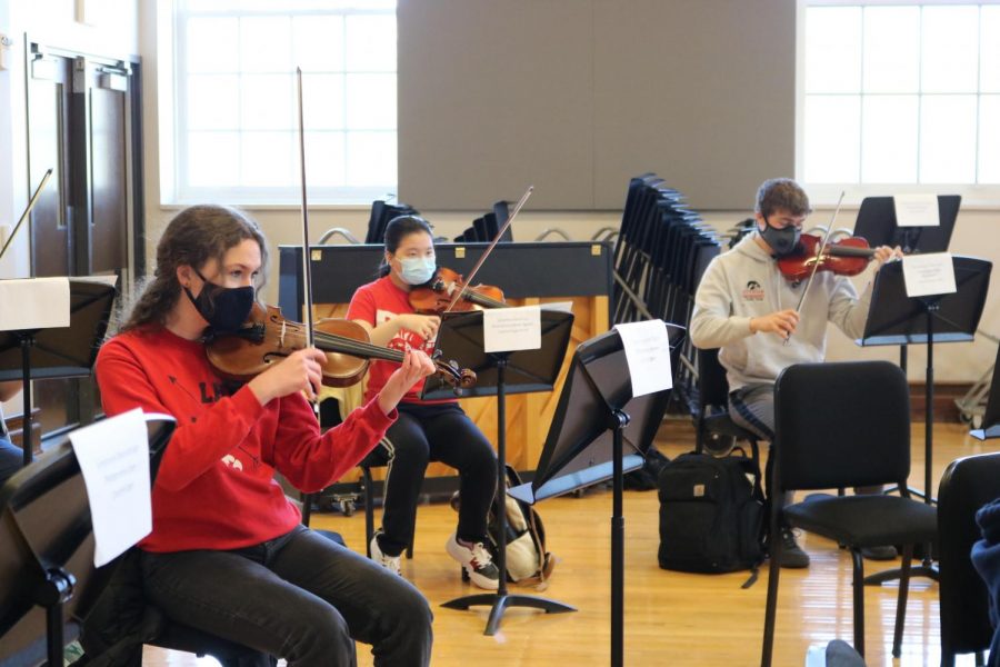 Jennie Gidal 23 (left) attends an in-person orchestra rehearsal 