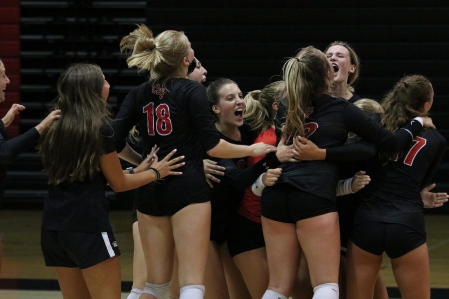 The+varsity+volleyball+team+celebrates+their+win+against+Linn-Mar.