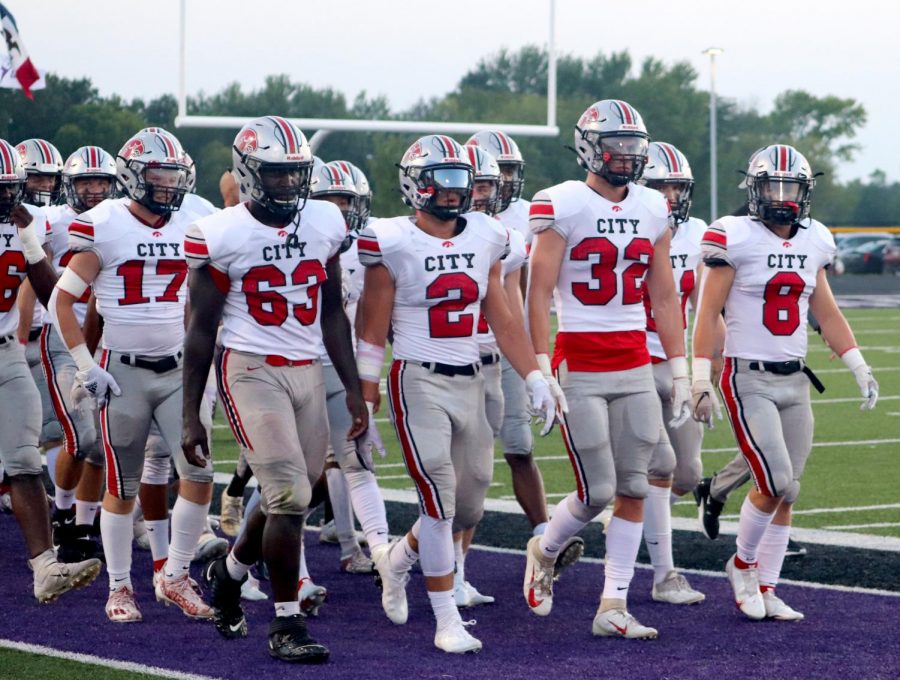 Little Hawk football captains led by Ben Kueter take the field for the Battle for Zeus.