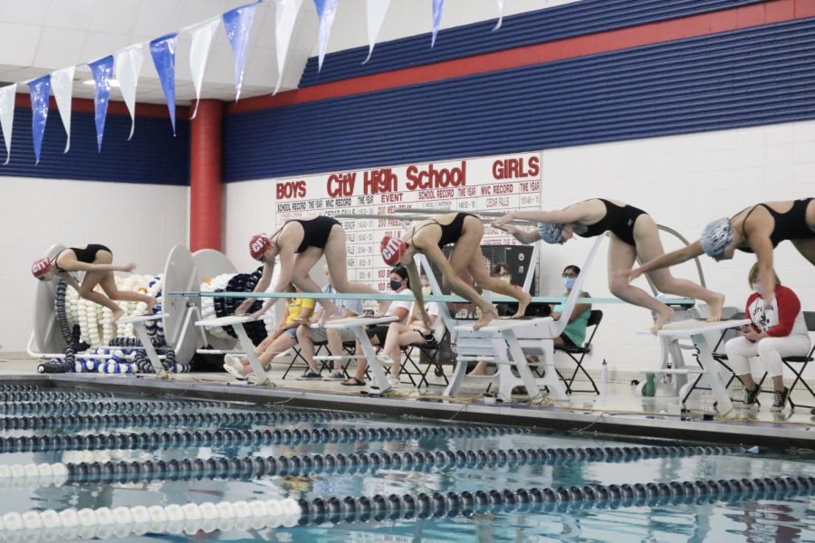 City High swimmers dive into the water at their meet against Linn-Mar.