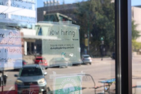 A “Now Hiring” sign hangs in the window of Dumpling Darling, a restaurant in downtown
Iowa City,