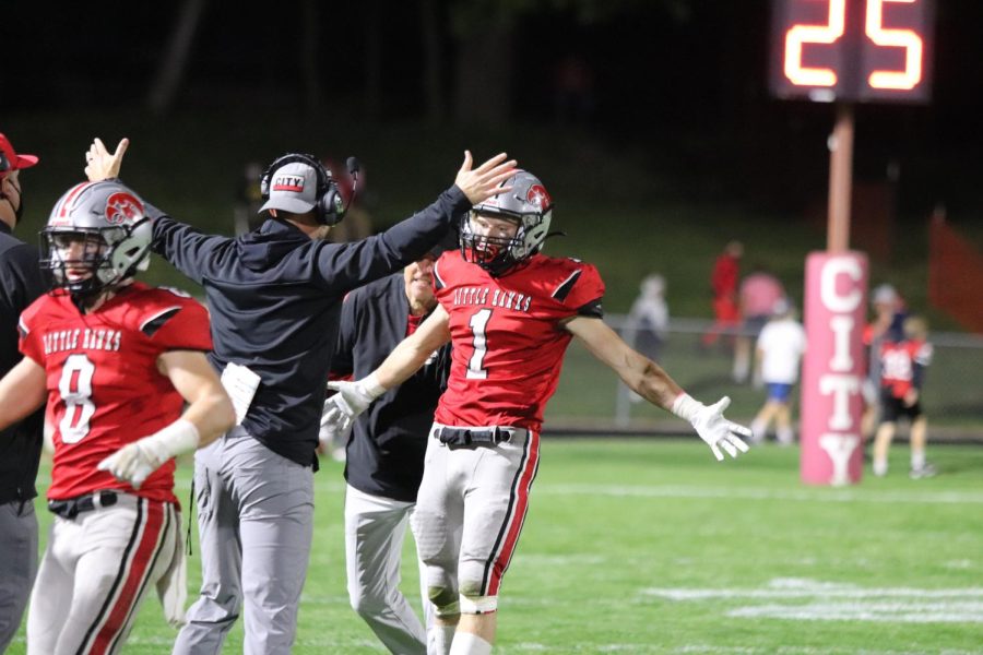 Joey Bouska 22 and Head Coach Mitch Moore celebrate a score against West High