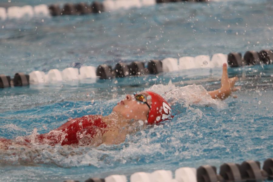 Kalea Seaton 24 swims backstroke in a meet against Dubuque Senior