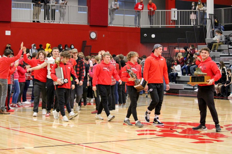 The football team carries all their trophies into the pep rally before leaving to go to the Dome to take on SE Polk.