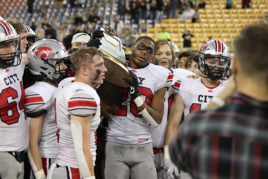 The City High football team accepts their state participant trophy.