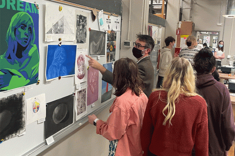 Students and art teacher Michael Close viewing prints at the art show.