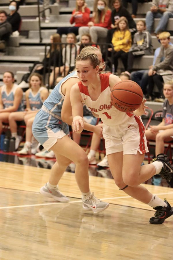 Emmy McComas '25, the only freshman on the varsity team, makes a layup in the home season opener. 