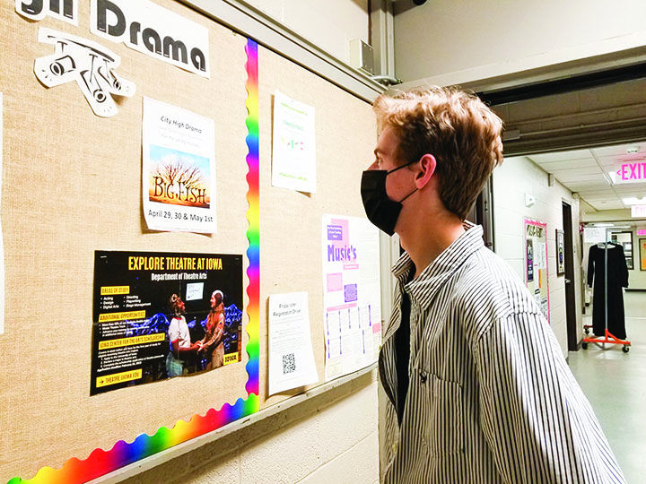 Charlie Faden 22 inspects a City High Drama poster promoting the upcoming spring musical Big Fish, which was on Broadway 8 years ago.