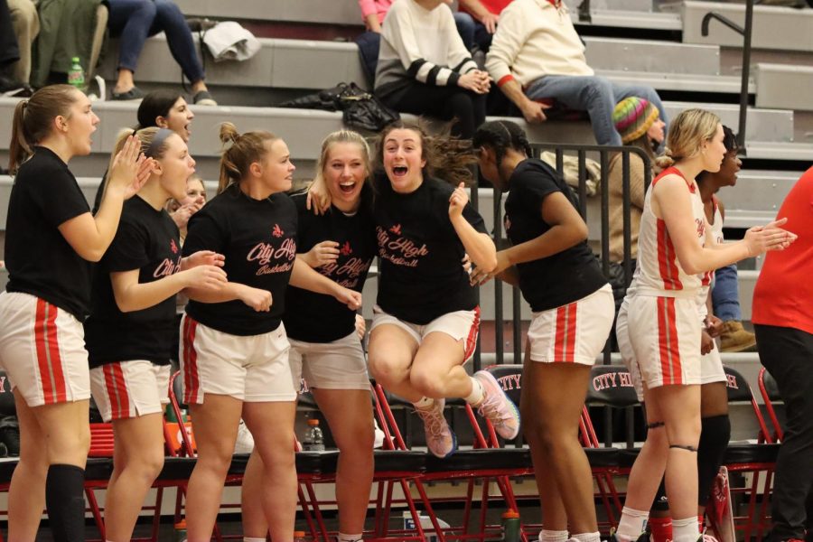 Players on the bench celebrate as City High takes the lead in the fourth quarter in the game against Waterloo West. 