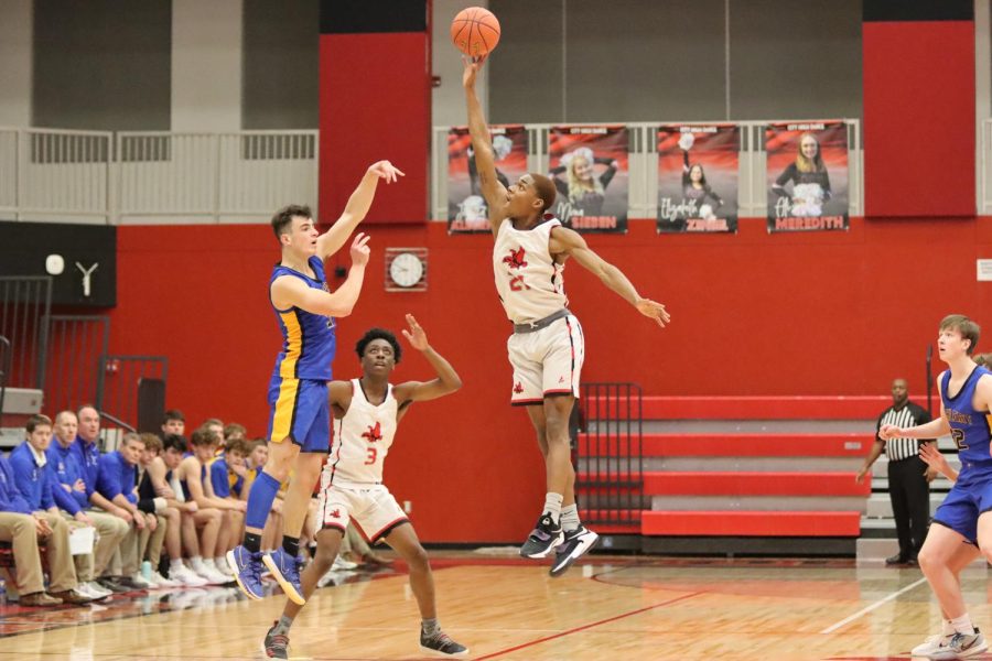 Jovan Harris '22 jumps to block 3 point shot by Wahlert Catholic.