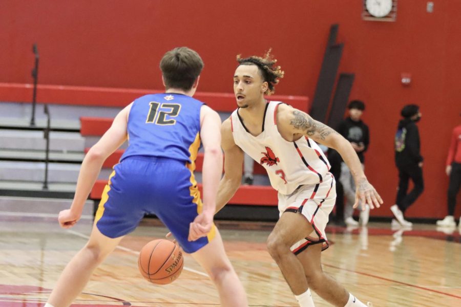 Jamari Newson '22 dribbles around the court looking for an open teammate in the home game against Wahlert Catholic.