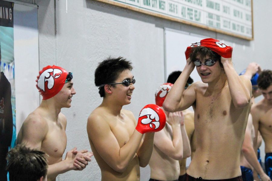 A group of City Highs mens swimmers laugh wile preparing for the meet.