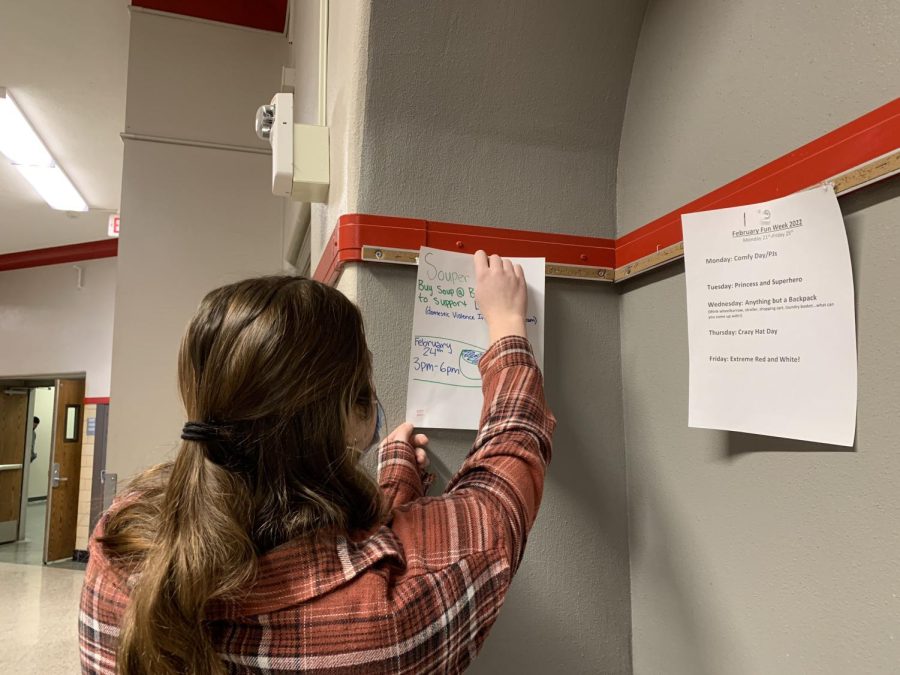 Interact Club member Ava Cross '23, hangs up a poster for the Soup-er Bowl.
