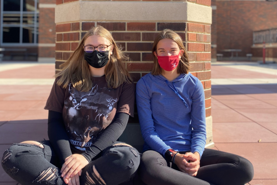Ella Sherlock ’23 and Sophie Stumbo ’23 are both passionate about nature and the outdoors, they sit in front of the statue in the new section of the building.