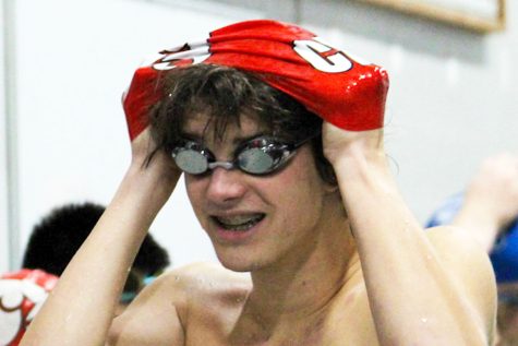 Charlie Pfohl 24 puts a swim cap on before a race.