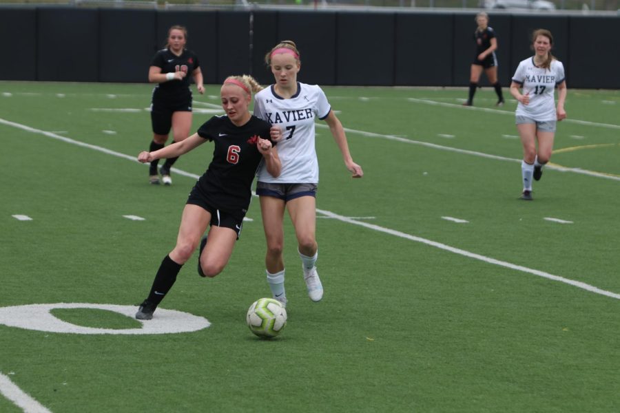 Ava Bell 24 battles a Xavier defender for the ball. 