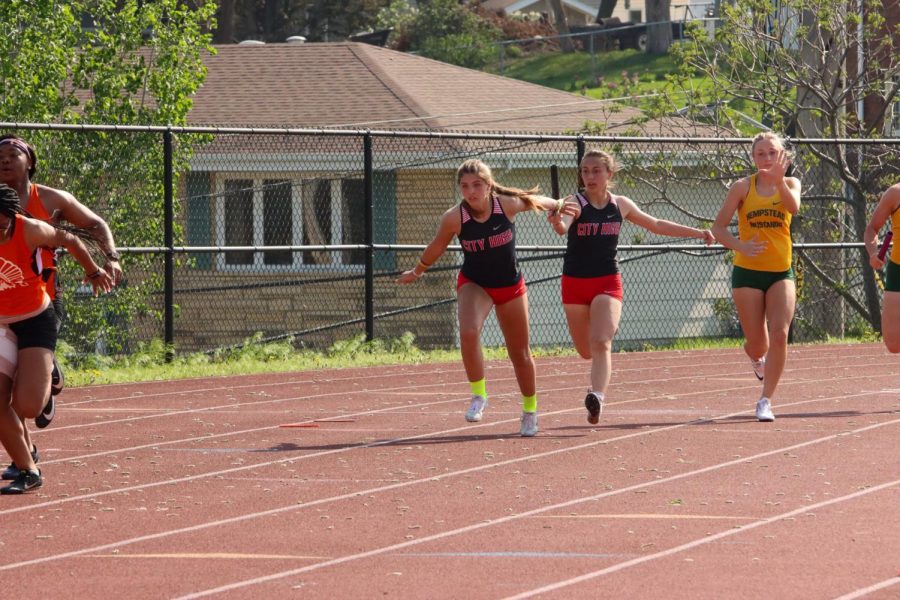 Safia Almabrazi '23 hands off the baton to Claire Brown '24 during the sprint medley relay. The team of Almabrazi, Brown, Mia DePrenger '22, and Ani Wedemeyer '25 qualify for state