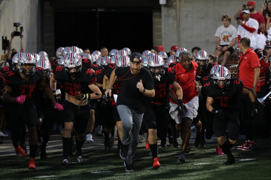 Coach Moore leads the City High football team out of the tunnel at the start of the first quarter. 